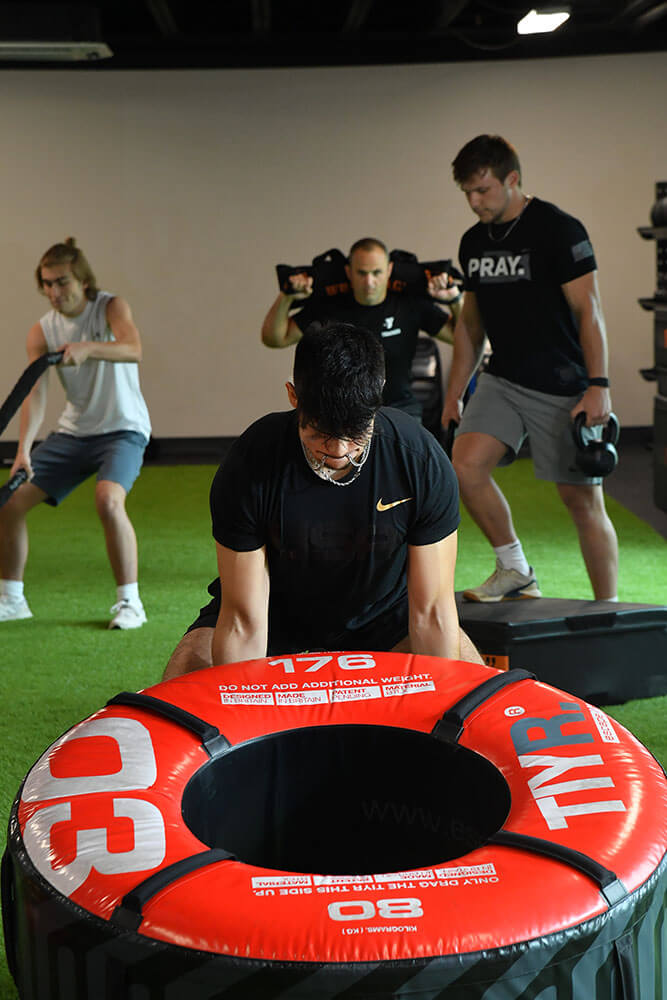 Muscular guy lifting heavy tire.