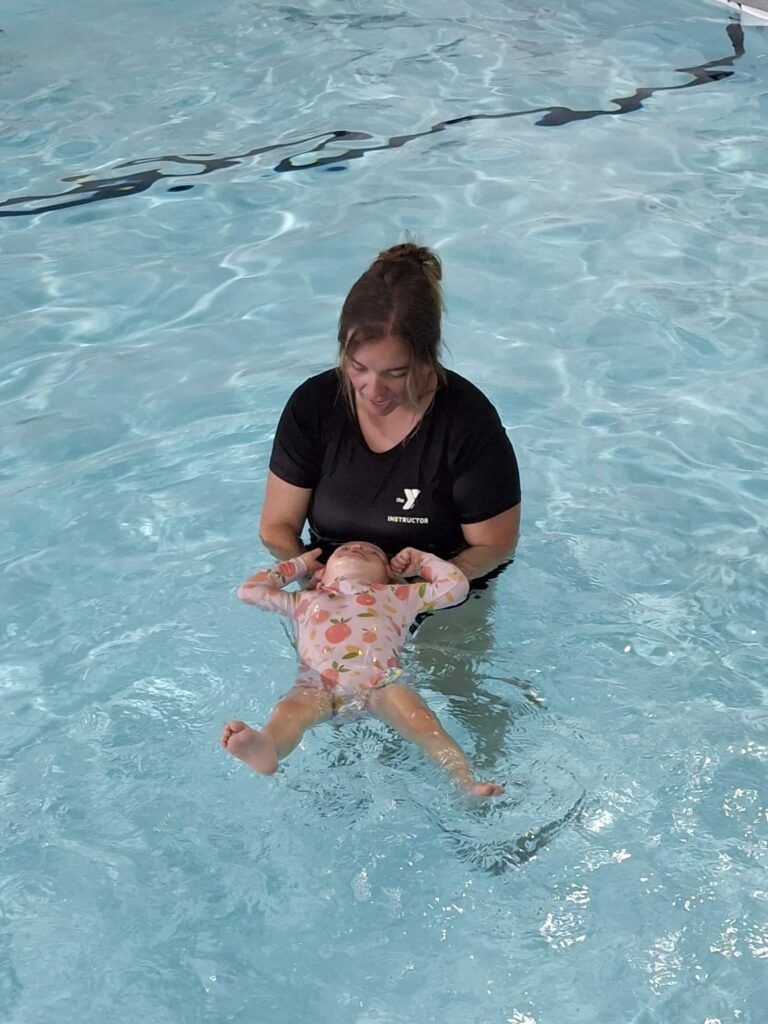 Baby Infront of Little floaters sign